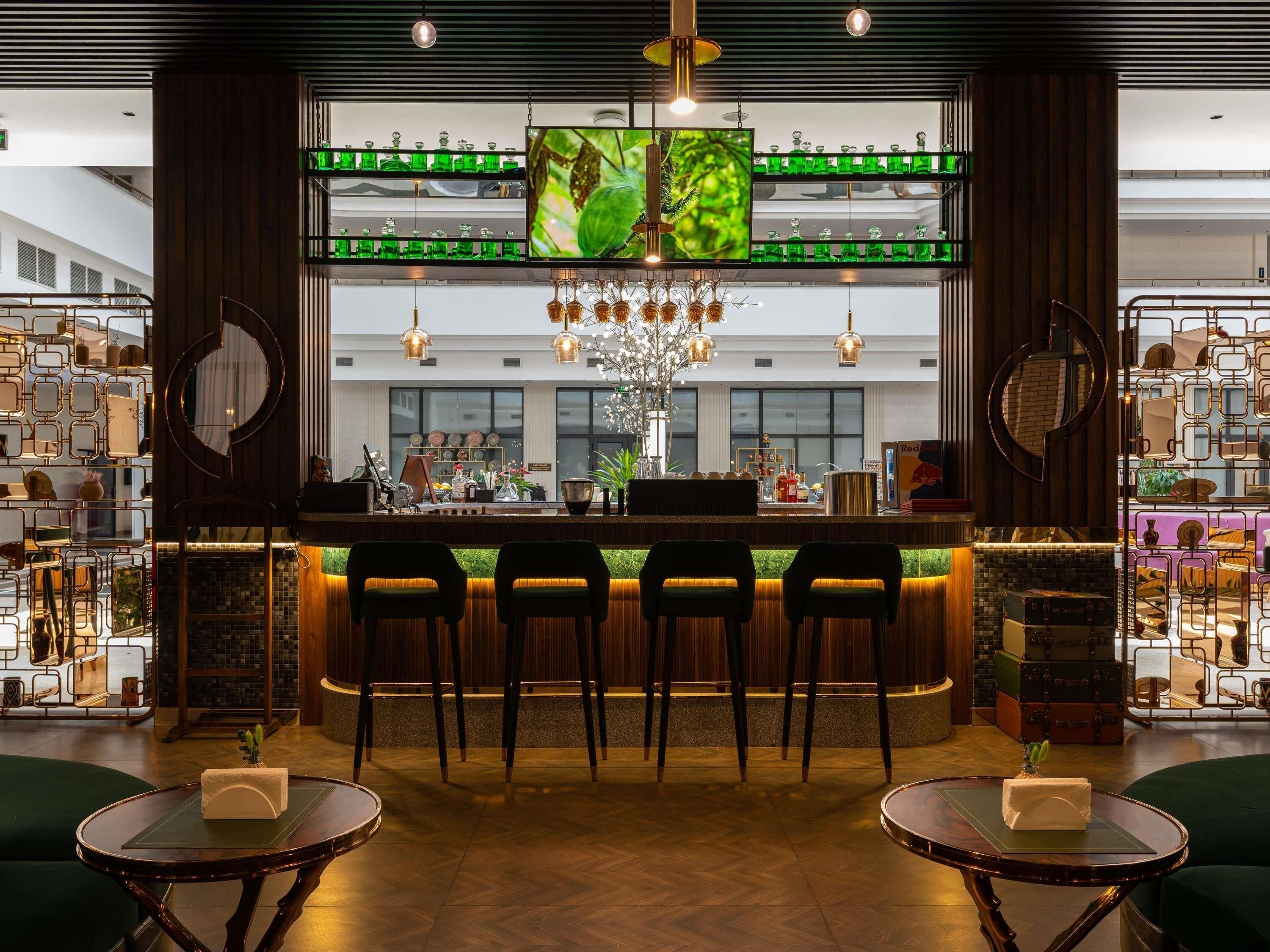 Eine Bar mit Fernseher, Barhocker und einem Kronleuchter.