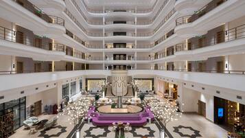 A multi-level atrium with a central circular seating area, multiple floors, and a variety of seating arrangements.