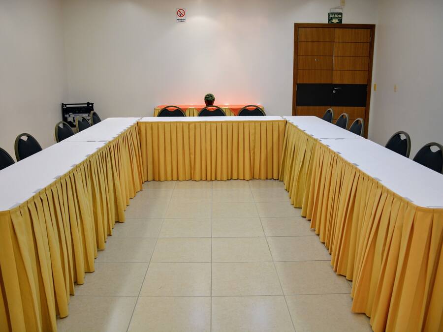 A conference room with a long table, chairs, and a door.