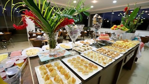 Um buffet com diversos alimentos e um arranjo de flores.