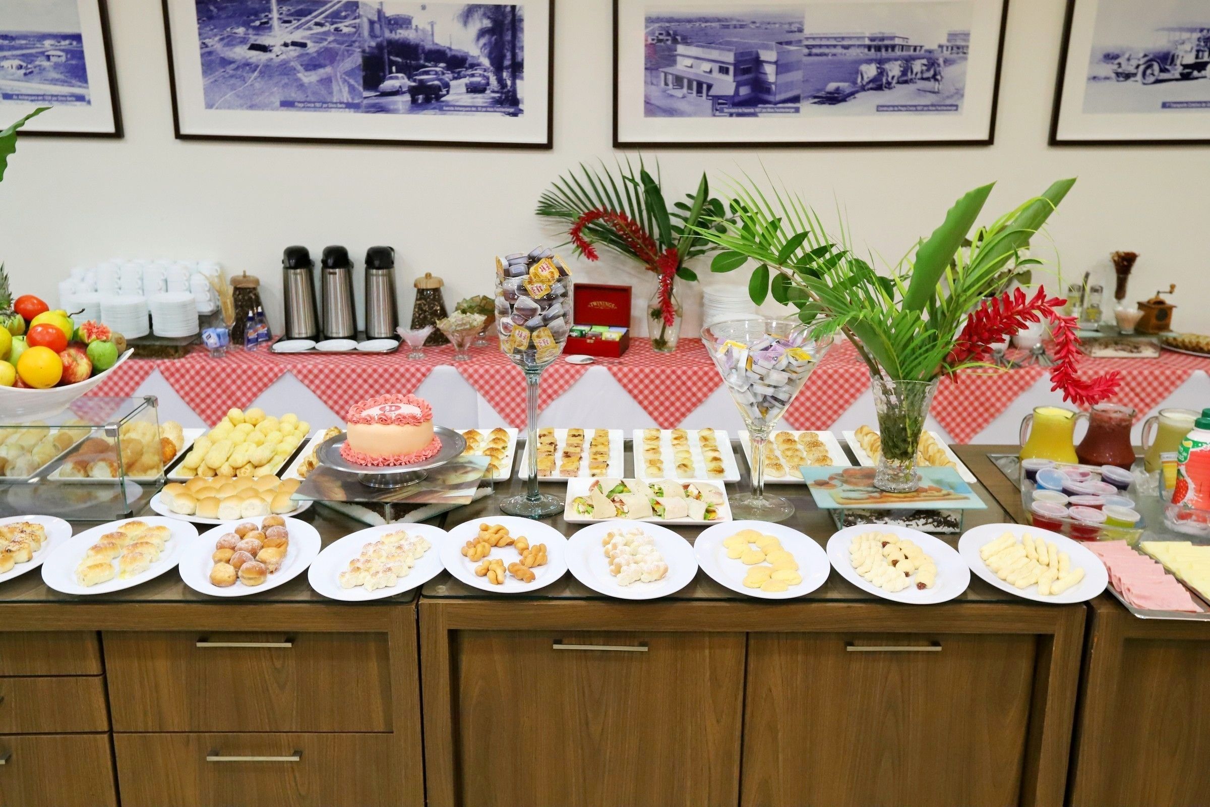 Uma mesa de buffet com diversos alimentos e uma planta decorativa.