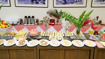 Uma mesa de buffet com diversos alimentos e uma planta decorativa.