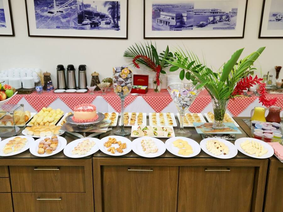 Uma mesa de buffet com diversos alimentos e uma planta decorativa.