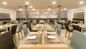 A restaurant with multiple tables, chairs, and a central decorative wall. - Jaime I (Benidorm)