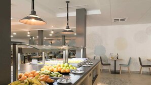 A modern breakfast bar with fruit and beverages, contemporary lighting, and a city view. - Jaime I (Benidorm)