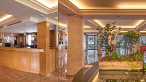 A hotel lobby with a reception desk, marble flooring, and a central column with a planter. - Jaime I (Benidorm)