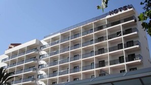 A multi-story hotel with balconies on each floor, a clear sky, and a sign indicating it is a hotel. - Jaime I (Benidorm)