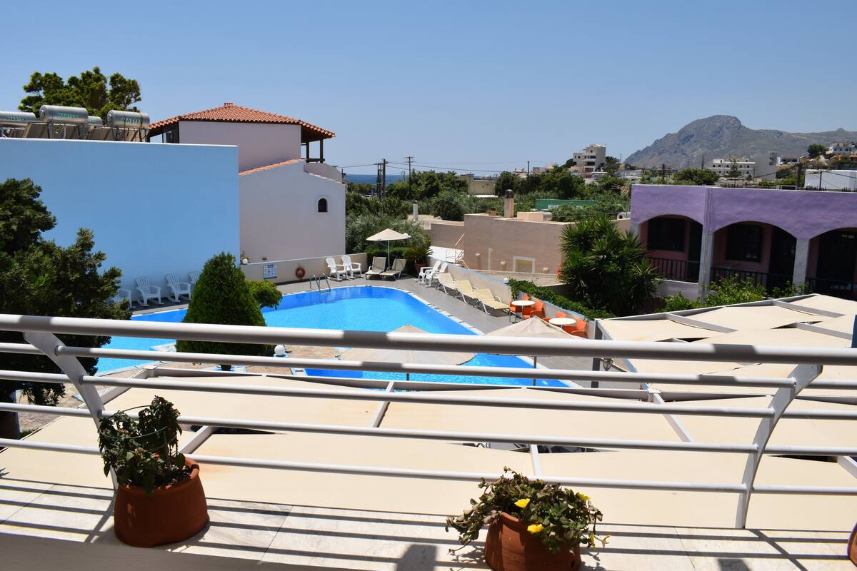 A rooftop pool area with a clear view of the surrounding buildings and a mountain in the distance.