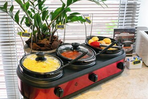 Een buffetopstelling met diverse gerechten en een bordje met de tekst 'Mexicaans eten'.