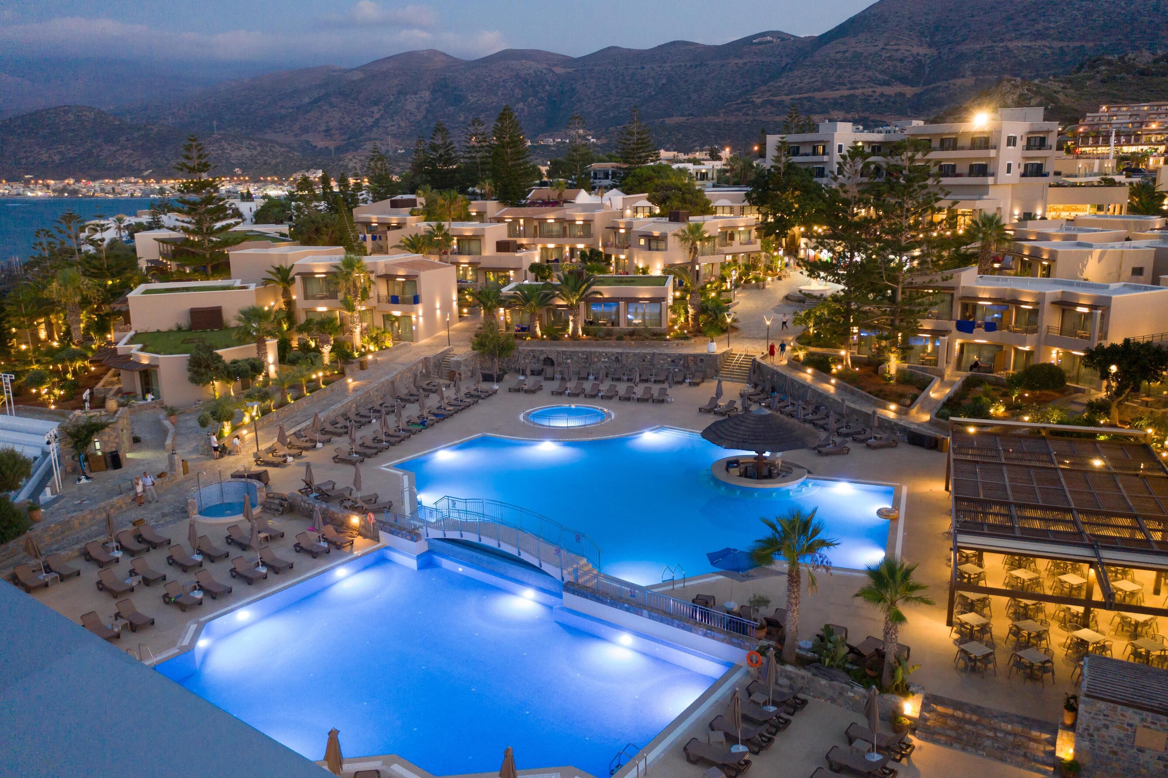 Et resort med flere swimmingpools, liggestole og havudsigt.