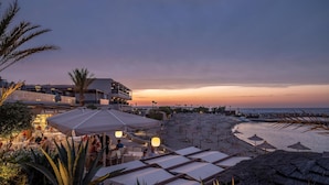 A beachside restaurant with outdoor seating and umbrellas, overlooking the sea. - Nana Golden Beach - All Inclusive (Hersonissos)