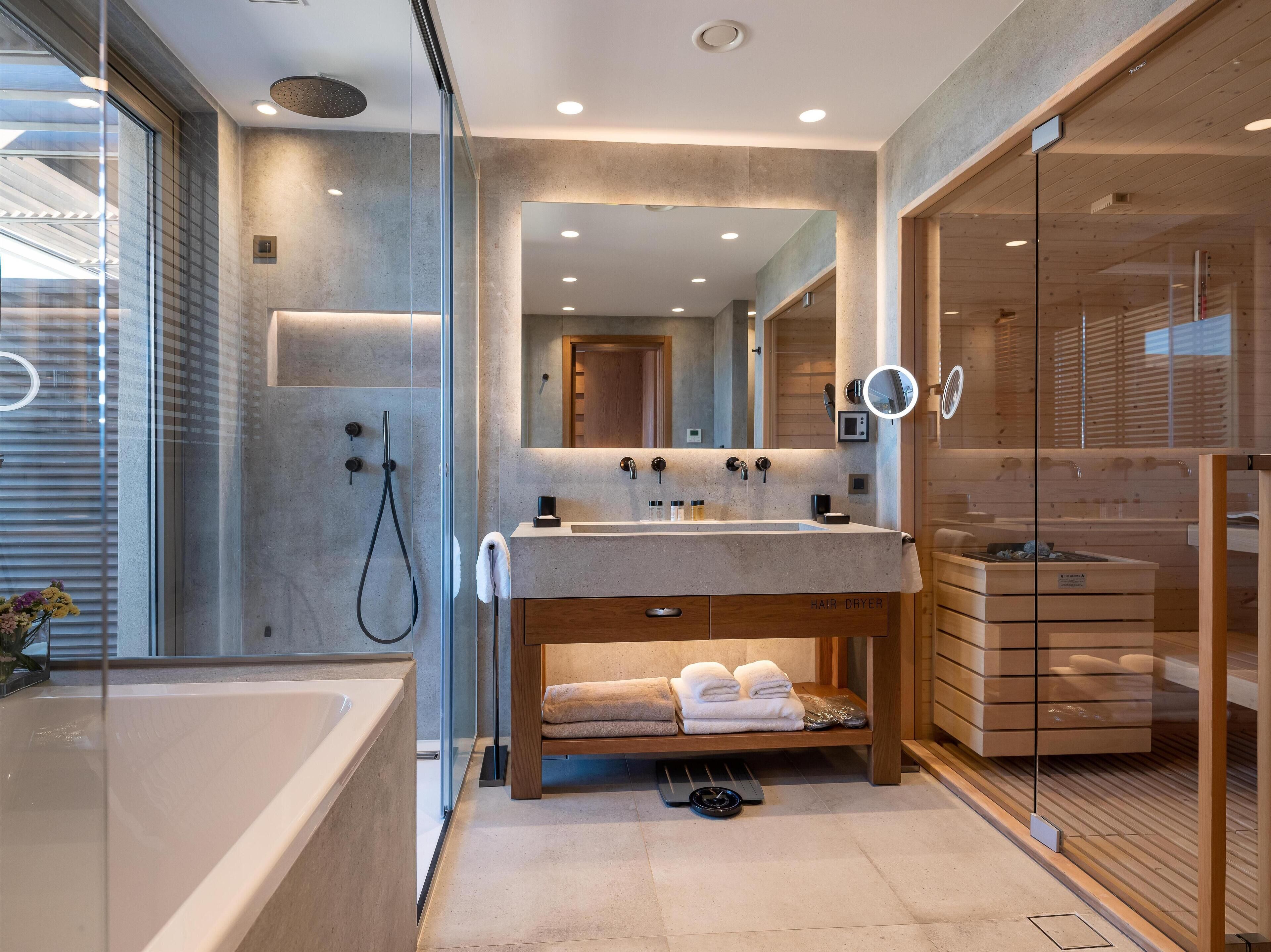 A modern bathroom with a large bathtub, a glass-enclosed shower, and a vanity with a mirror.
