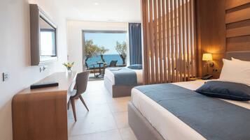 Una habitación de hotel moderna con una cama grande, un escritorio, una silla y vista al mar.