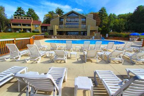 A pool area with multiple lounge chairs and a pool. - Tanglwood Resort (Hawley)