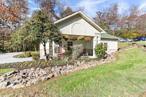 A two-story building with a red door, a covered porch, and hanging flower baskets.