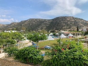 Un resort con piscina, mobiliario exterior y vistas a las montañas.