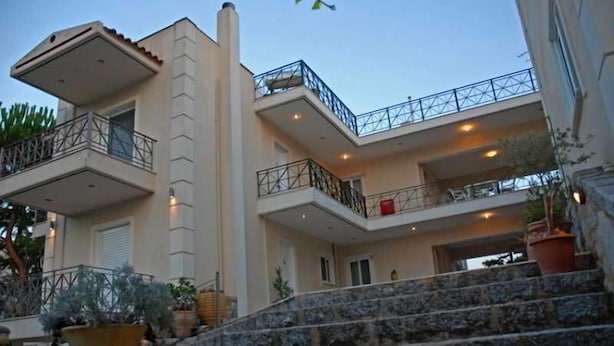 A multi-story building with balconies, stone steps, and potted plants.