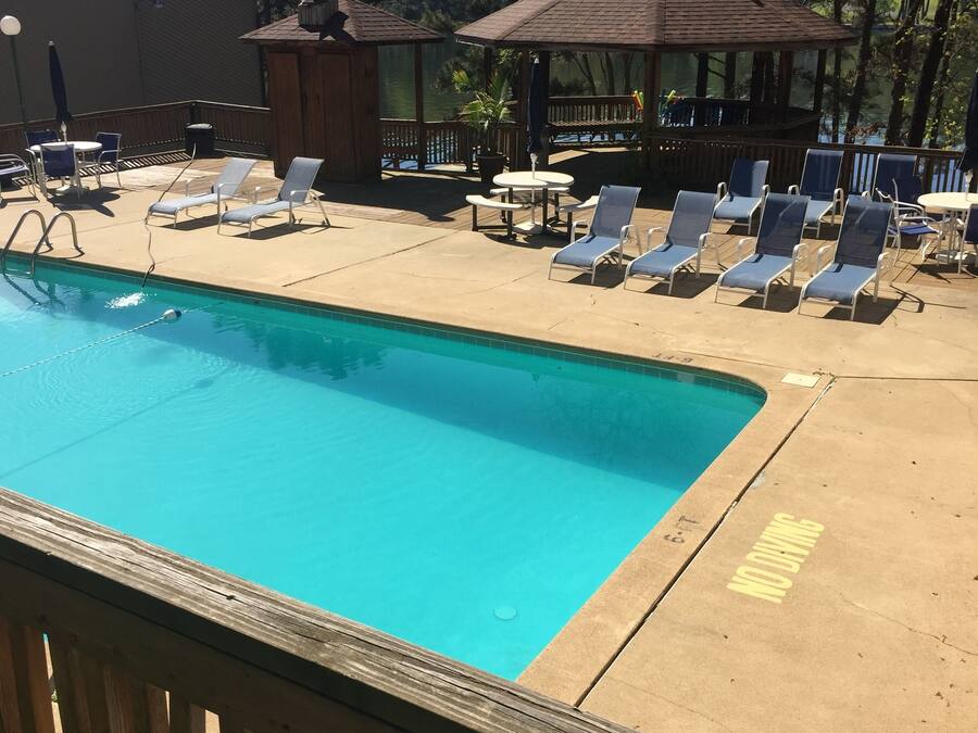 A pool area with lounge chairs and a gazebo.