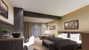 A hotel room with a bed, a desk, a chair, a bedside table, and a large window with curtains. - Belgrade Boutique House (Belgrade)