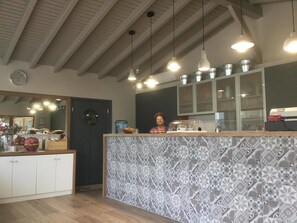 A modern kitchen with a patterned backsplash, wooden cabinets, and pendant lighting. - Ariadnes Holiday Accommodation II (Lesvos)