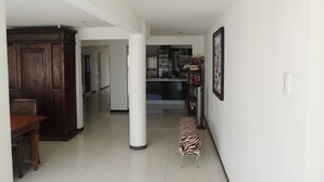 A spacious hallway with a dining area, a kitchen, and a zebra-patterned bench. - Sun Sea Sleep B&B (Willemstad)