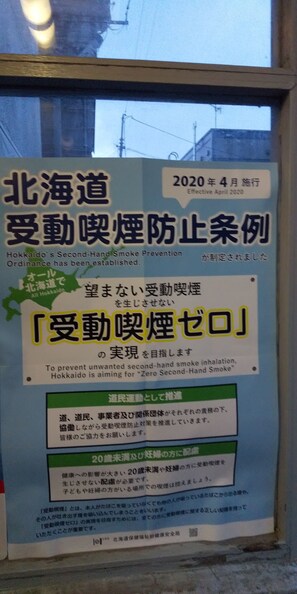 Un letrero en japonés con texto sobre la ordenanza de prevención del humo de segunda mano en Hokkaido.
