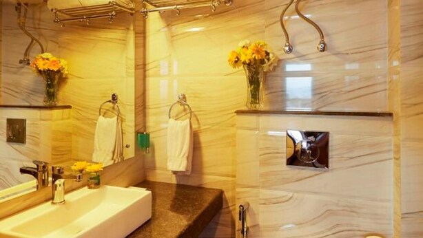 Ein modernes Badezimmer mit einem großen Waschbecken, einem Spiegel und einer Toilette.