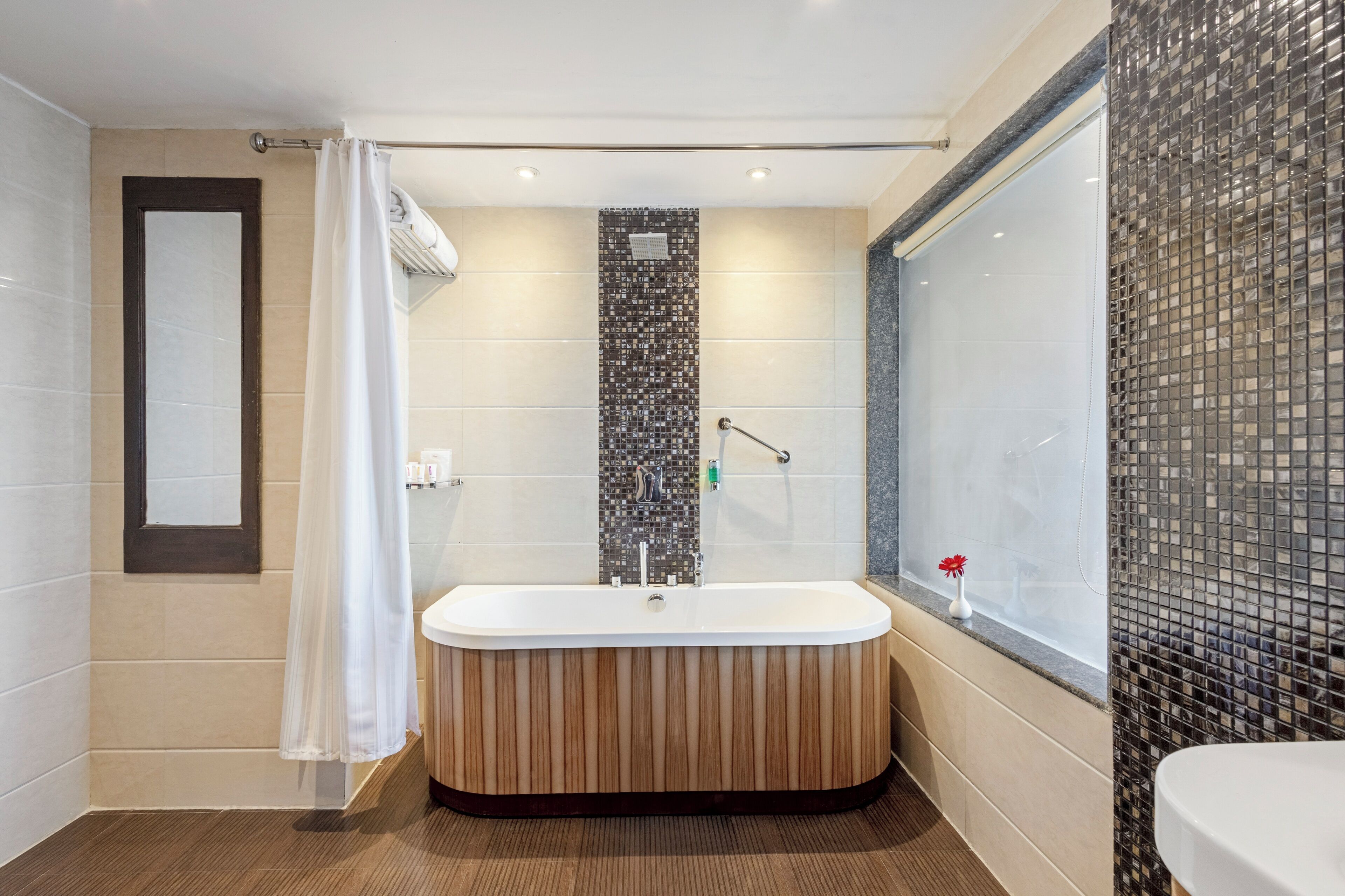 A modern bathroom with a freestanding bathtub, a shower area, and a large window with a view.