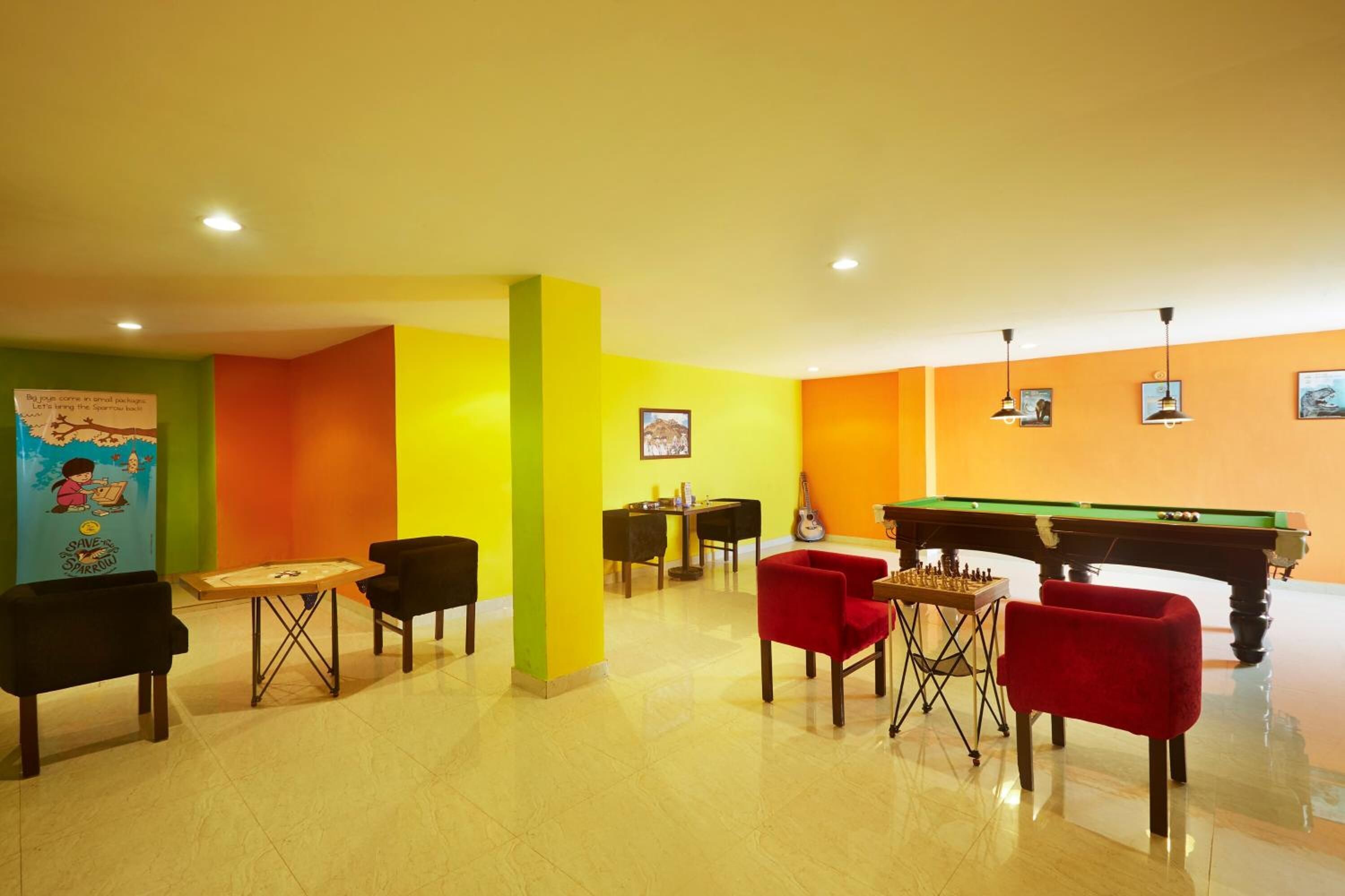 A brightly colored room with a pool table, foosball table, and a table tennis table.
