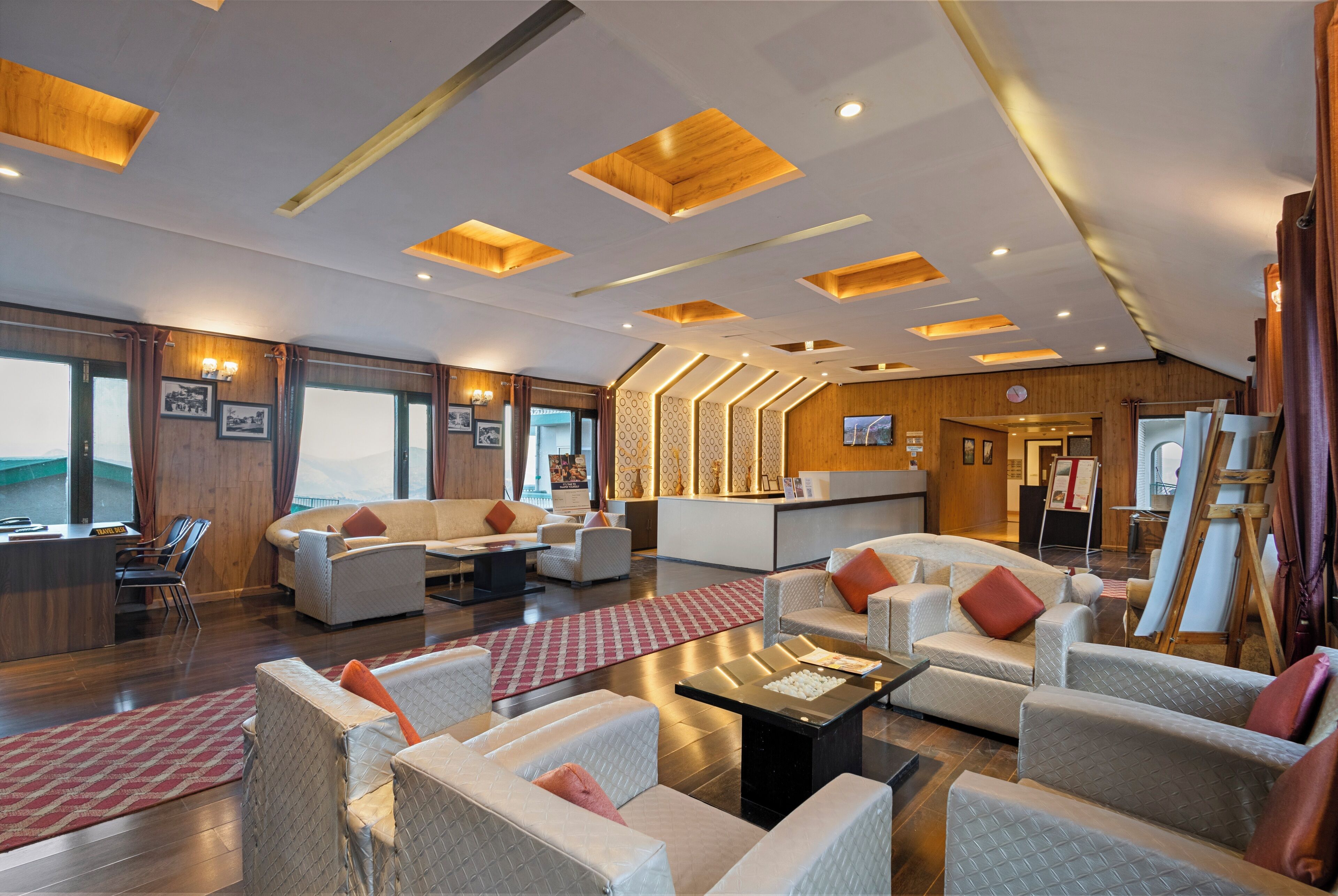 A spacious lobby with modern furniture, a reception desk, and a large window offering a view.