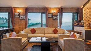 A modern living room with a sofa and armchairs, a coffee table, and large windows with a view. - Sterling Kufri (Theog)