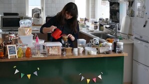 A kitchen counter with various items like a coffee maker, jars, and a red mug. - Otaru Ekimae Guest House Ito - Hostel (Otaru)