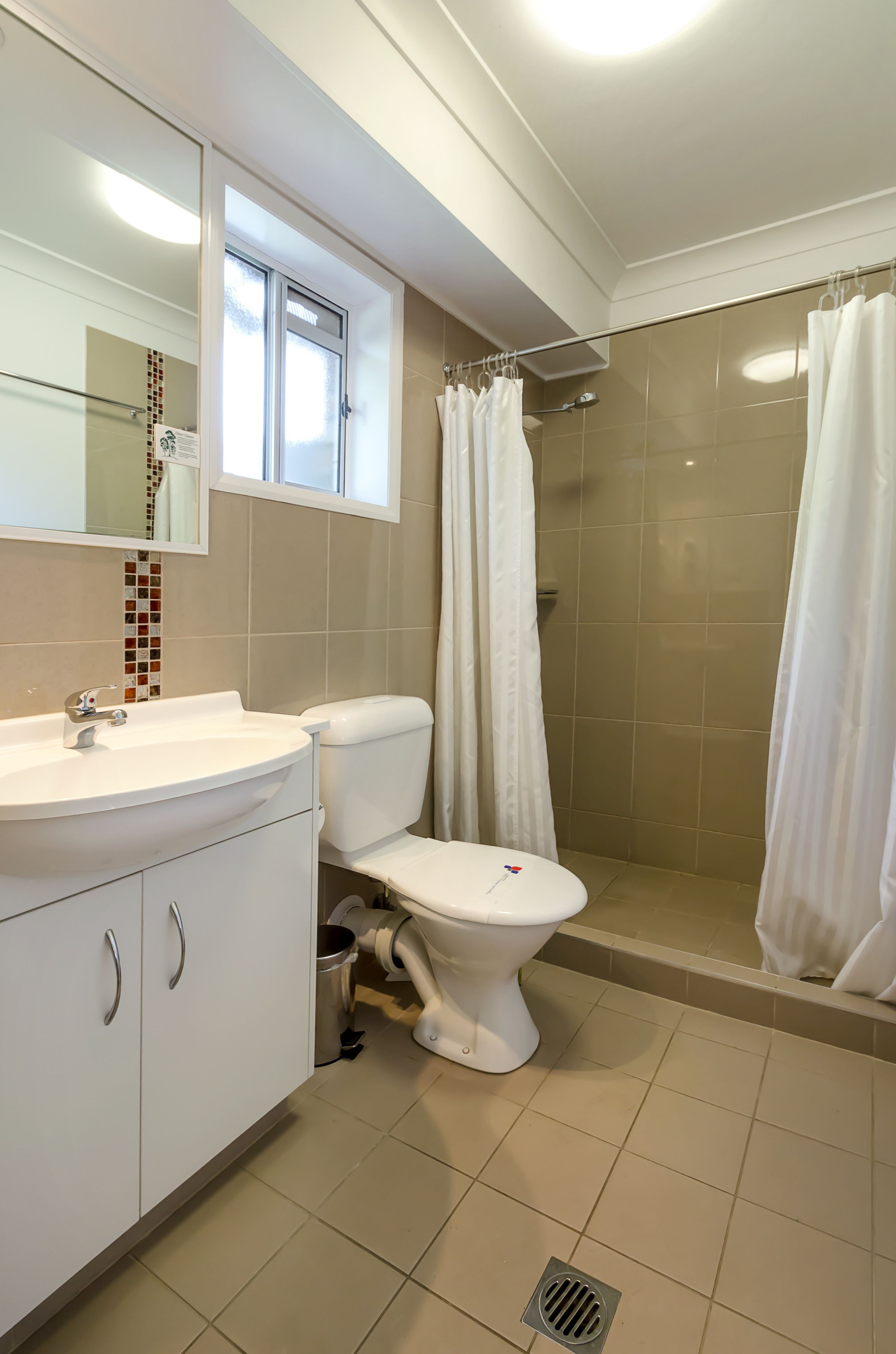 A bathroom with a toilet, sink, and shower.