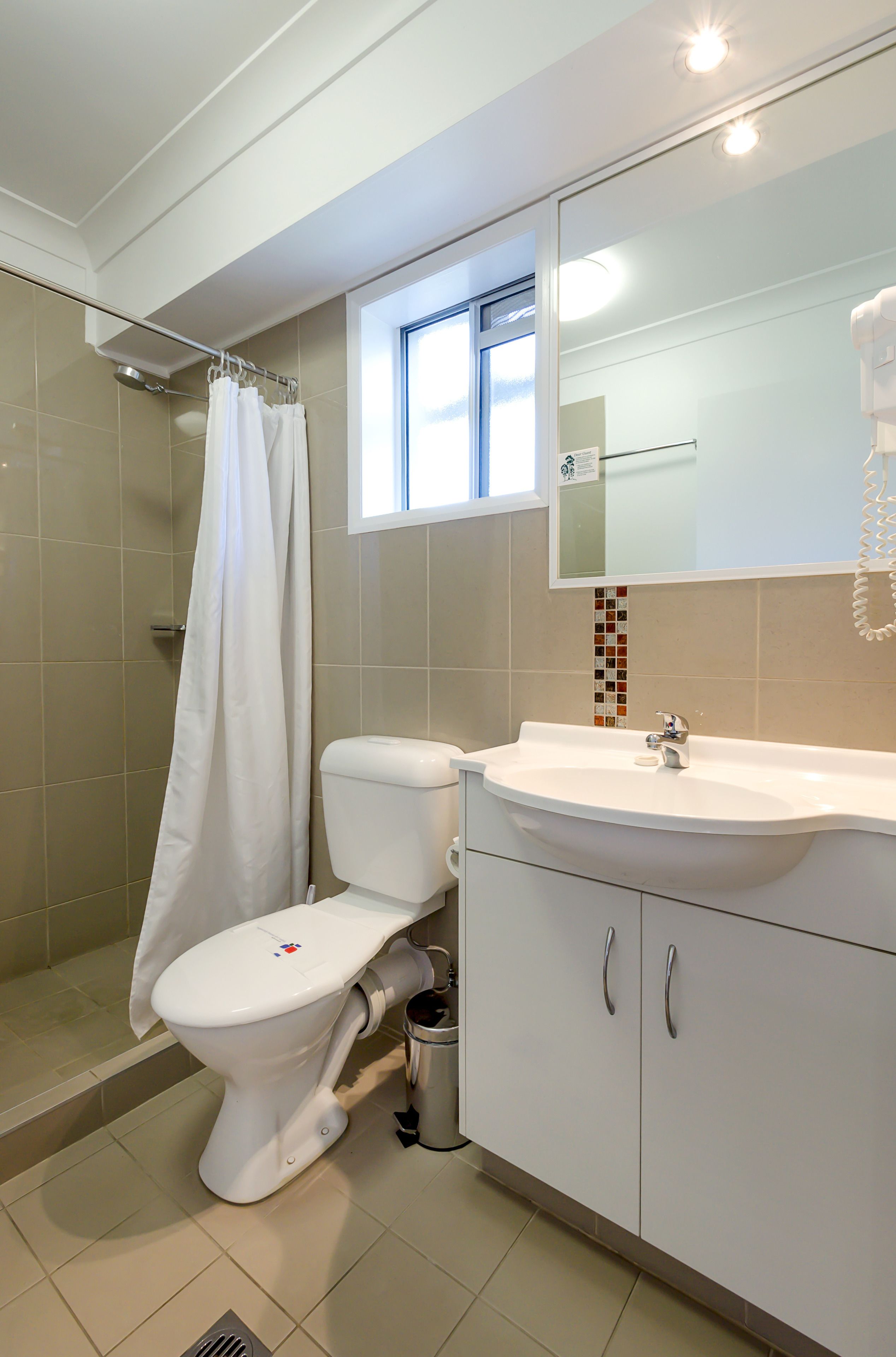 Een badkamer met toilet, wastafel en douche.