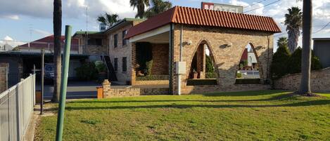 Un edificio de ladrillo con techo rojo, un porche cubierto y un cartel que indica que es un motel.