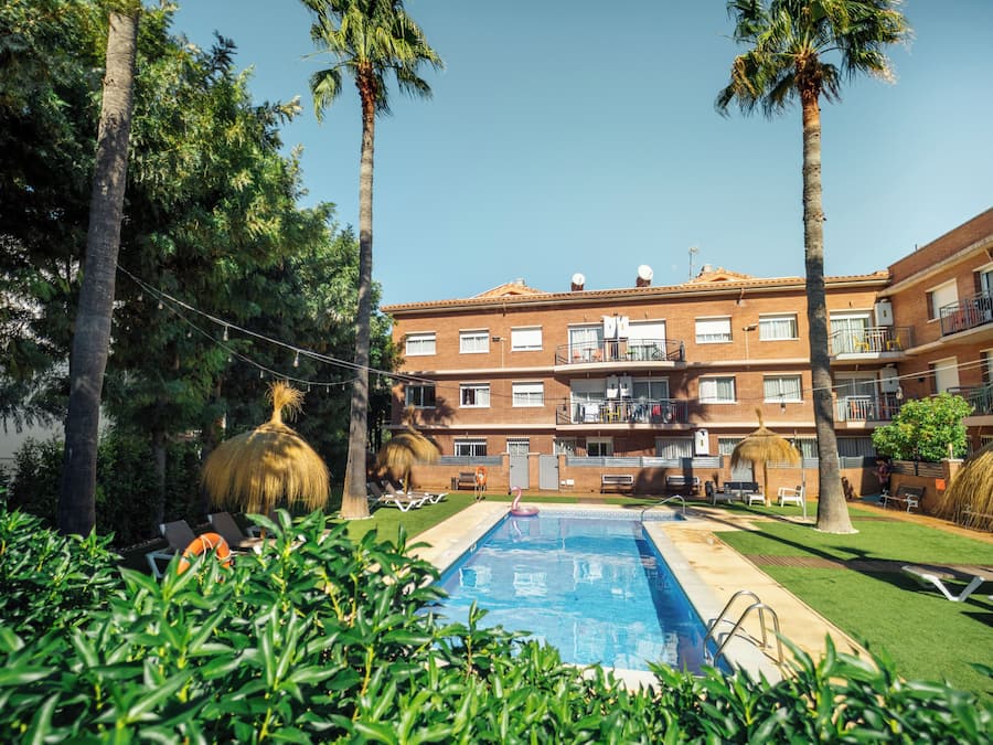 Una piscina al aire libre, sombrillas, sillones reclinables de piscina
