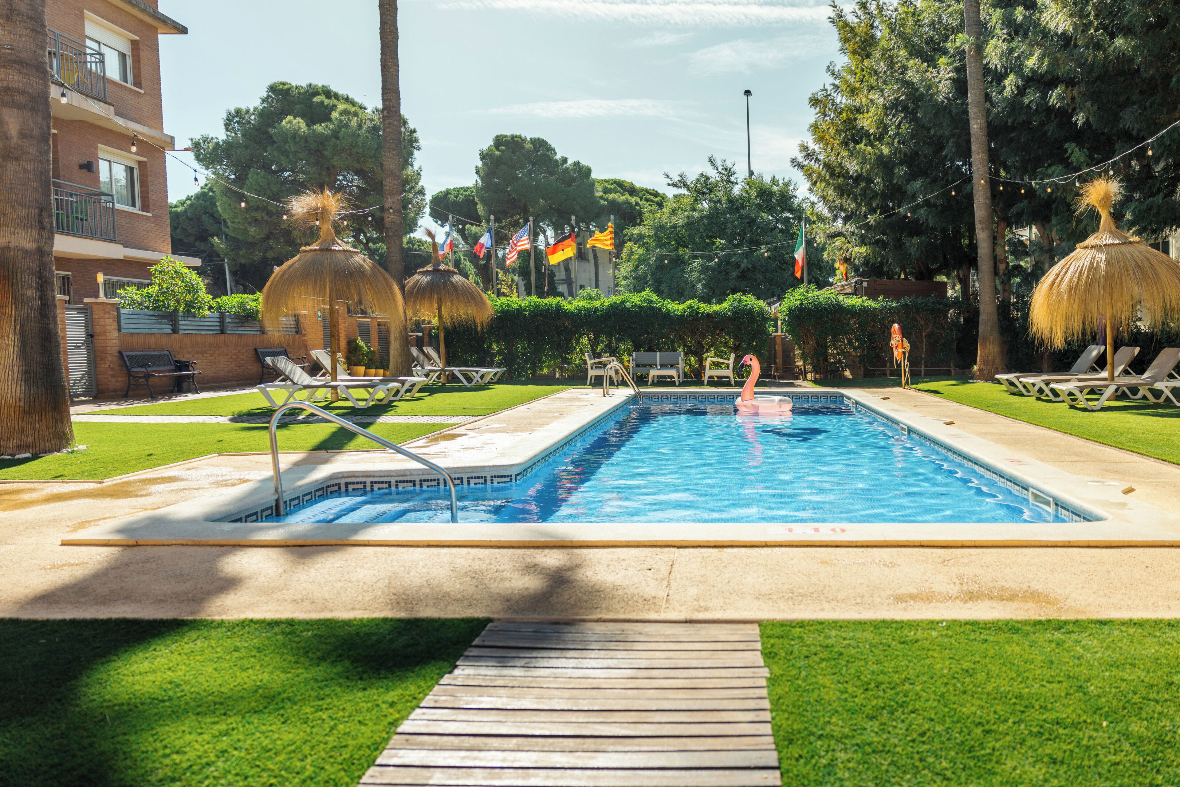 室外游泳池，池畔遮阳伞，日光浴躺椅