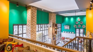A vibrant interior with a staircase, green walls, and a view of the outside.