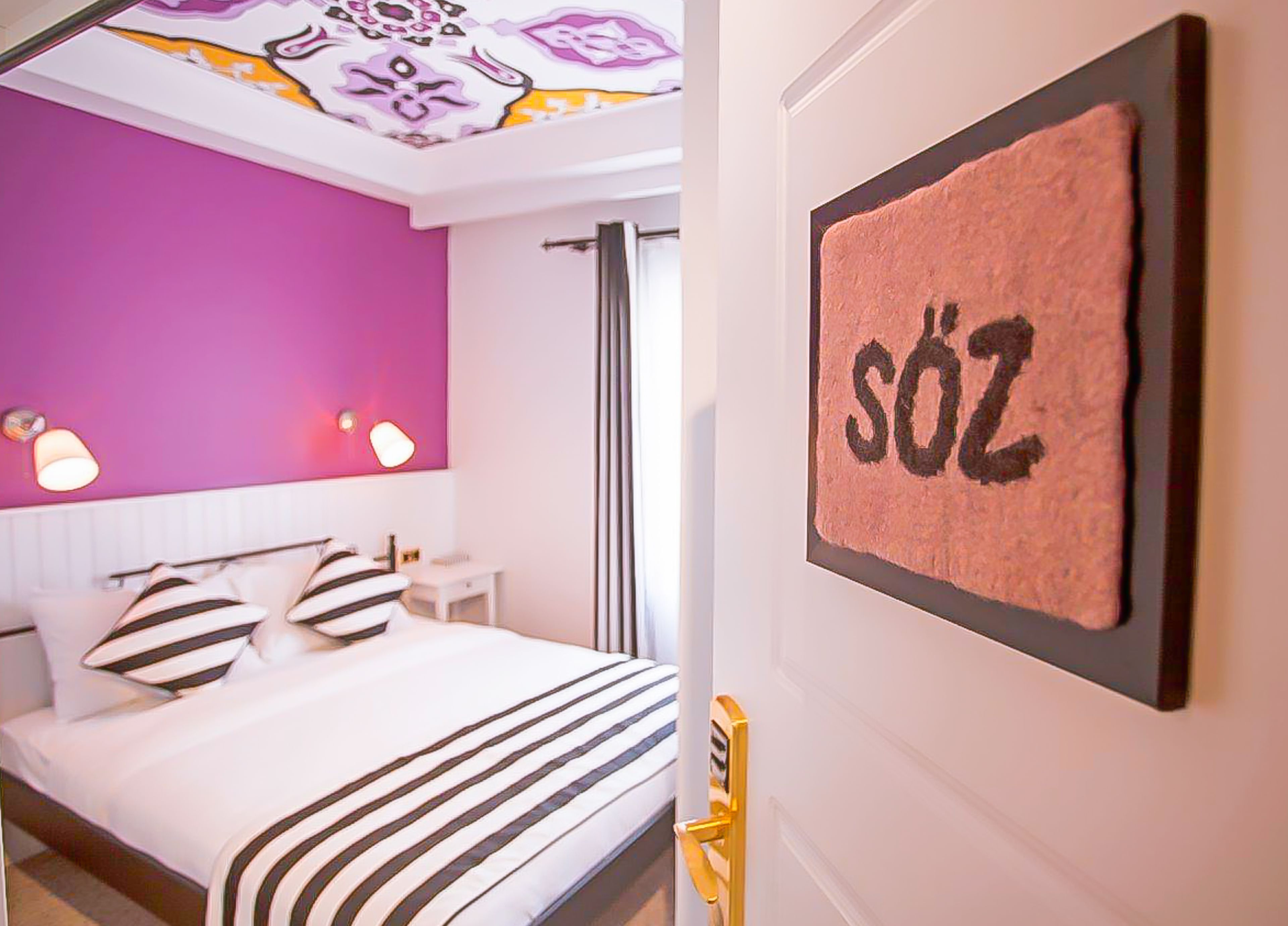 A modern hotel room with a bed, a nightstand, and a bathroom with a shower.