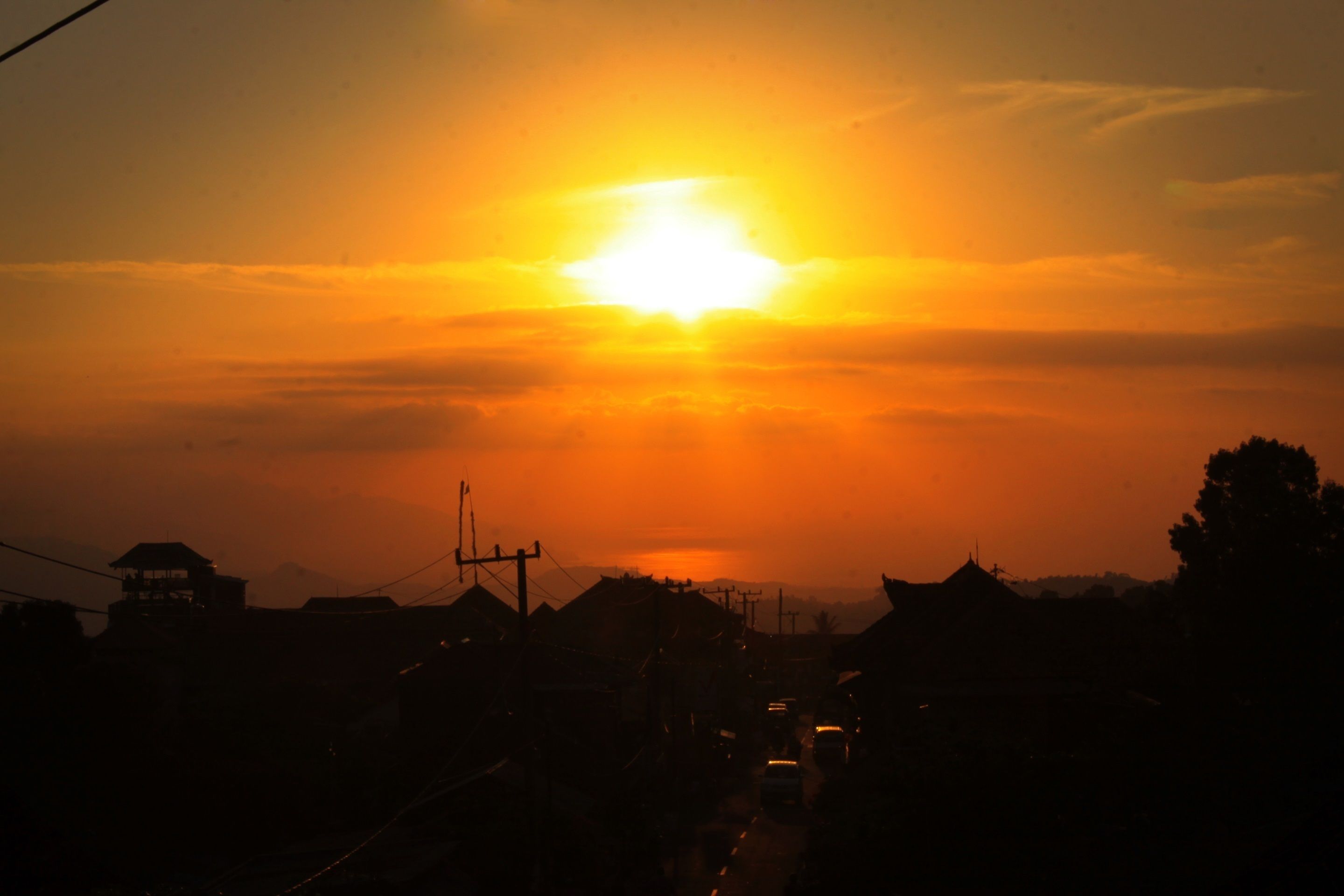 Un atardecer sobre una zona residencial con casas y una carretera.