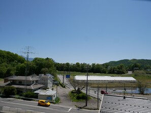 Ein Wohngebiet mit Häusern, einer Straße und einem großen Industriegebäude.