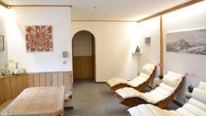 Um quarto de spa com móveis de madeira, uma pintura grande e vista para as montanhas.