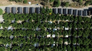 Vista aérea de una zona residencial con varias casas unifamiliares, un estacionamiento y una calle.