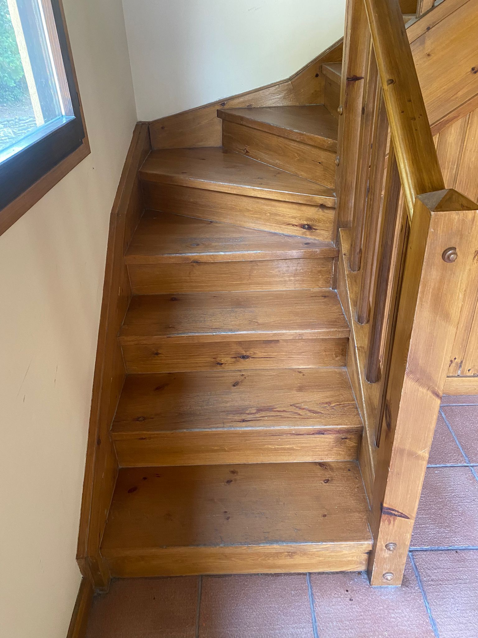 A wooden staircase with a handrail, leading to an upper floor.