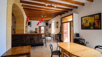 Un café amplio con vigas de madera, una zona de bar y una mesa de comedor.