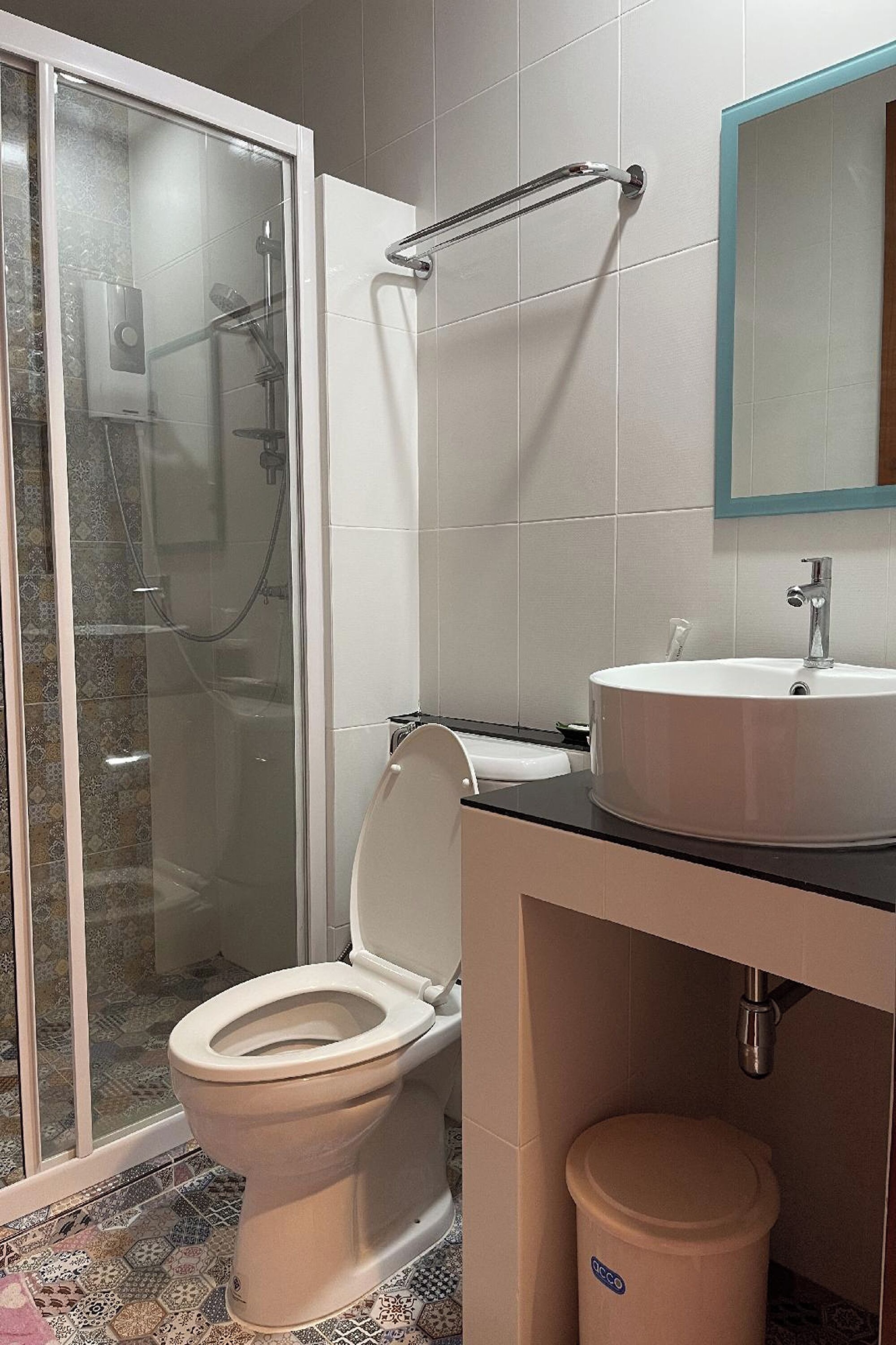 A bathroom with a toilet, sink, and shower area.