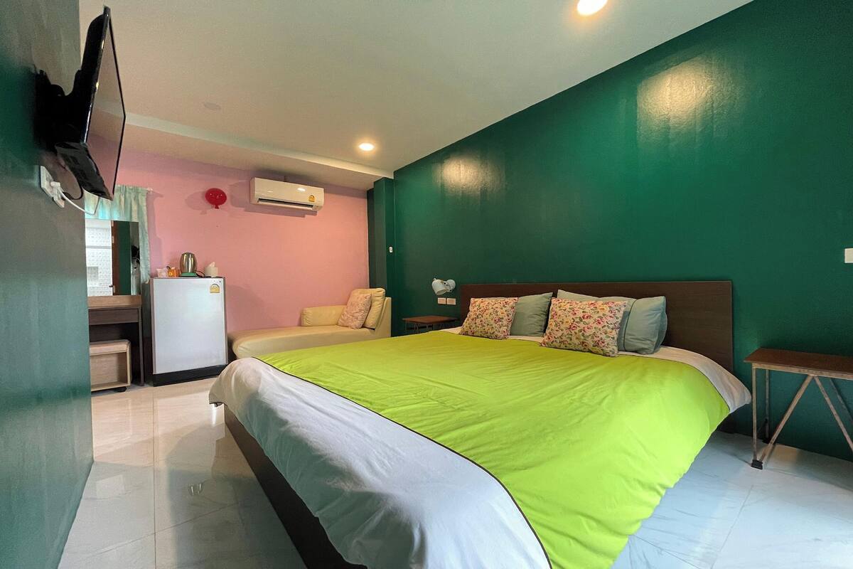 Une chambre d’hôtel équipée d’un lit, d’un bureau, d’une chaise, d’une télévision et d’un appareil de climatisation.