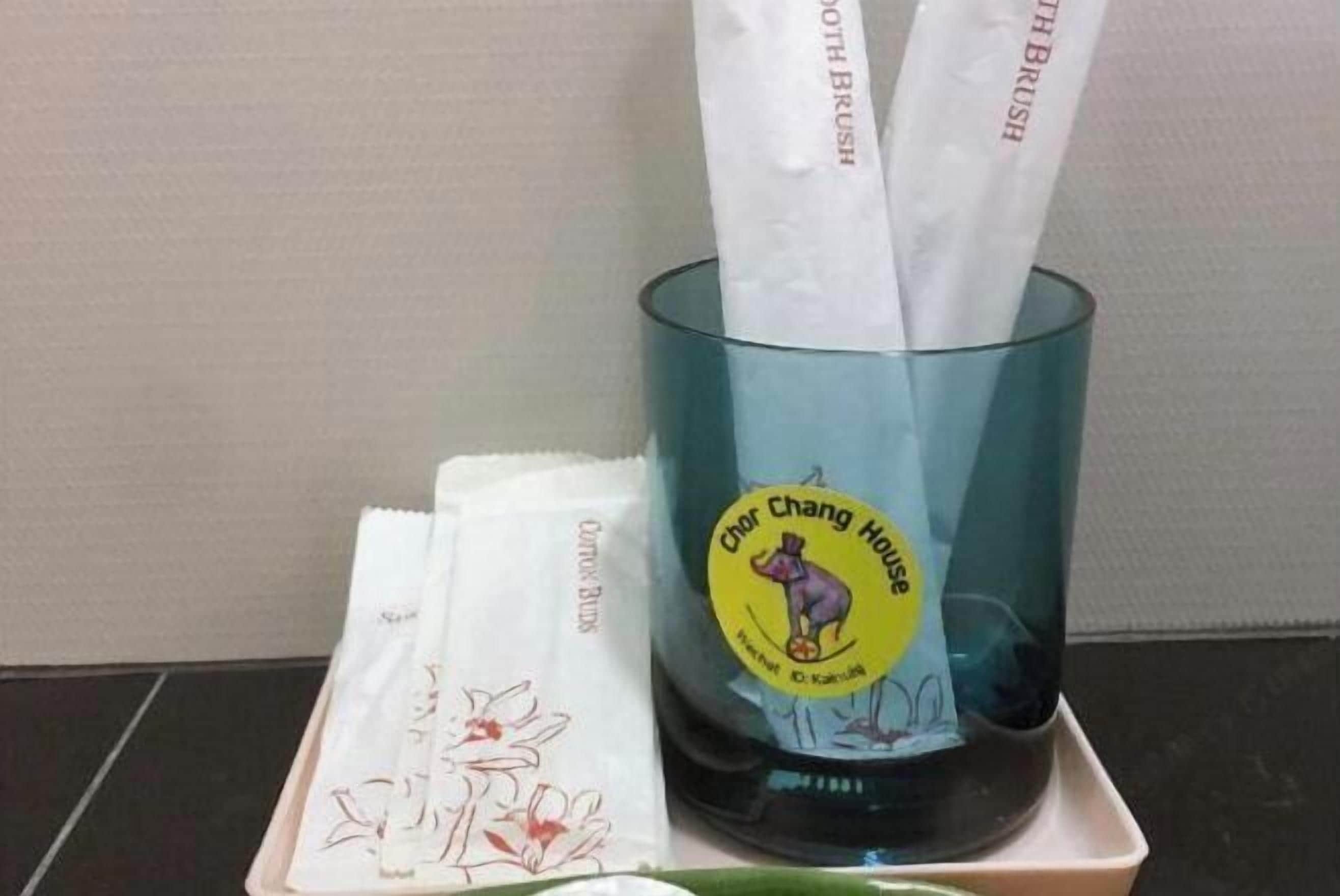 Un recipiente de vidrio con una etiqueta que dice "Chor Chang House" y un paño blanco con diseño floral.