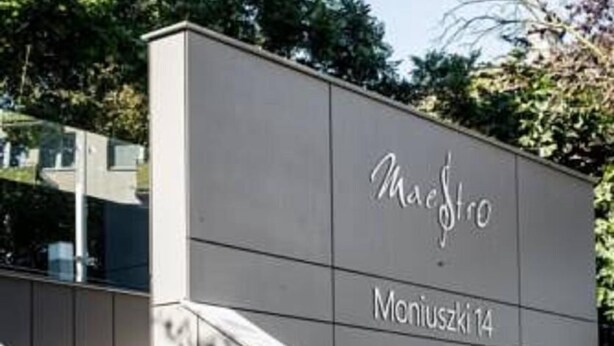 Fachada moderna de un edificio con un letrero que dice "Maestro Moniuszko 14" y "bmc".