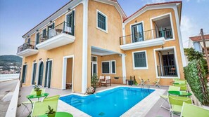 Una piscina al aire libre, sombrillas, tumbonas